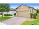 Front exterior view of house with a brick paver driveway and attached 2 car garage at 1028 Salamanca Pl, Davenport, FL 33837