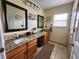 Bright bathroom with double sinks, granite countertops, and ample natural light from the window at 10549 Cypress Trail Dr, Orlando, FL 32825