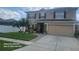 Two-story home featuring a manicured lawn, two-car garage, and stone pillar accents at 10549 Cypress Trail Dr, Orlando, FL 32825
