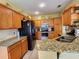 Well-equipped kitchen featuring granite countertops, wood cabinetry, and modern appliances at 10549 Cypress Trail Dr, Orlando, FL 32825