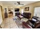 Cozy living area featuring leather seating, tile floors, and an entertainment center at 10549 Cypress Trail Dr, Orlando, FL 32825
