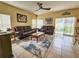 Comfortable living room with leather furniture, a ceiling fan, and sliding glass doors to the yard at 10549 Cypress Trail Dr, Orlando, FL 32825