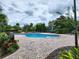 Community pool surrounded by lush landscaping and brick pavers, offering a relaxing outdoor space at 10549 Cypress Trail Dr, Orlando, FL 32825