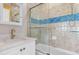Cozy bathroom featuring vanity with stone countertop, and a tiled shower/tub with sliding glass door at 11018 Lake Butler Blvd, Windermere, FL 34786