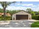 Spacious two car detached garage with neutral stucco and a large driveway and manicured landscaping at 11018 Lake Butler Blvd, Windermere, FL 34786