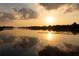Stunning golden hour lake view with reflections of the sky in the calm water at 11018 Lake Butler Blvd, Windermere, FL 34786