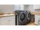 Laundry room featuring sink, counter space, storage cabinets, modern washer, and modern dryer at 11018 Lake Butler Blvd, Windermere, FL 34786