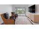 Comfortable living room featuring wicker chairs, entertainment center, and sliding doors that leads to balcony at 11018 Lake Butler Blvd, Windermere, FL 34786