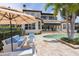 Inviting backyard featuring a sparkling pool, travertine patio, and comfortable lounge area with blue cushions at 11018 Lake Butler Blvd, Windermere, FL 34786