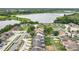 An aerial view of homes in a community near a lake with lush green trees, and clear blue skies at 1113 Woodman Way, Orlando, FL 32818
