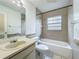 Well-lit bathroom featuring a tub, toilet, sink with vanity, and tiled walls at 1113 Woodman Way, Orlando, FL 32818
