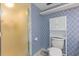 A compact full bathroom features patterned walls, a shower, and a toilet with shelving at 1135 Thunder Trl, Maitland, FL 32751