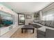 Bright living room with a gray sofa, a large mirror, built-in shelving, and an area rug at 1135 Thunder Trl, Maitland, FL 32751