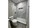 Bathroom with gray tile walls, walk-in shower, shower niche and white toilet at 1139 Poppy Ave, Orlando, FL 32811