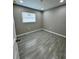 Serene bedroom with gray walls, wood-look tile flooring, and a single window offering natural light at 1139 Poppy Ave, Orlando, FL 32811