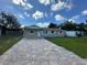Exterior view of a single-story home with brick driveway and green lawn at 1139 Poppy Ave, Orlando, FL 32811