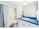 Clean bathroom with a shower and tub combination, white tile surround, blue accents, and great lighting at 1221 N Brickell Dr, Deltona, FL 32725