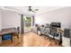Bedroom with hardwood floor, a ceiling fan, and a large window with a view of the fenced yard at 1221 N Brickell Dr, Deltona, FL 32725