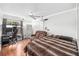 Comfortable bedroom with wood flooring, a projector, a bed, and a brown reclining sofa at 1221 N Brickell Dr, Deltona, FL 32725