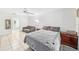Bright bedroom features tile floors, ceiling fan, and a gray sofa near the entry to the bathroom at 1221 N Brickell Dr, Deltona, FL 32725