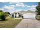 Charming single-story home with a well-manicured lawn, attached two-car garage, and inviting front entrance at 1221 N Brickell Dr, Deltona, FL 32725