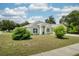 Charming single-story home featuring a well-manicured lawn, mature trees, and lush landscaping at 1221 N Brickell Dr, Deltona, FL 32725