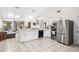 Modern kitchen with stainless steel appliances, white cabinets, breakfast bar and connecting living area at 1221 N Brickell Dr, Deltona, FL 32725