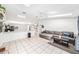 Open-concept living room with tile floors, a comfortable sectional sofa, and abundant natural light at 1221 N Brickell Dr, Deltona, FL 32725
