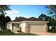 Charming single-story home with a two-car garage, stone accents, and well-manicured landscaping at 1369 Sawgrass Hammock Ln, Davenport, FL 33837