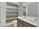 Bright bathroom featuring a double sink vanity, tile floors and a shower with patterned curtain at 15659 Carina Dr, Orlando, FL 32828