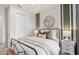 Cozy bedroom with a metal bed frame, striped accent wall, and stylish round mirror at 1811 Spring Shower Cir, Kissimmee, FL 34744