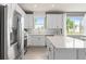 Modern kitchen with white cabinetry, stainless steel appliances, and a center island with seating, open to dining area at 1811 Spring Shower Cir, Kissimmee, FL 34744