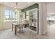 Well-lit office space boasts built-in bookshelves, a wooden desk, and neutral decor at 1811 Spring Shower Cir, Kissimmee, FL 34744