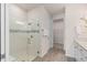 Modern glass enclosed shower with white tile and a shower seat, complemented by wood-look flooring at 1811 Spring Shower Cir, Kissimmee, FL 34744