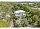 Aerial view of a modern home surrounded by lush landscaping with a glimpse of the lake at 1820 Englewood Rd, Winter Park, FL 32789
