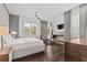 Modern bedroom with a flat-screen television, sitting area, gray drapes, and hardwood floors at 1820 Englewood Rd, Winter Park, FL 32789