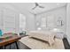 Neutral bedroom featuring a ceiling fan, large windows, dark floors and door leading to bathroom at 1820 Englewood Rd, Winter Park, FL 32789