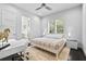 Neutral bedroom featuring a ceiling fan, large windows and door leading to bathroom at 1820 Englewood Rd, Winter Park, FL 32789