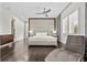 Modern bedroom with a gray upholstered headboard, chaise lounge, hardwood floors and recessed lighting at 1820 Englewood Rd, Winter Park, FL 32789