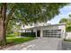 Modern home with a three-car garage, a large window, and a beautifully landscaped yard at 1820 Englewood Rd, Winter Park, FL 32789