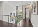 Bright hallway with modern railings, stone accent wall, and views of the manicured yard at 1820 Englewood Rd, Winter Park, FL 32789