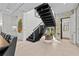 Modern staircase with black steps, metal railing, and a view to the outside at 1820 Englewood Rd, Winter Park, FL 32789