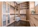 Spacious walk-in closet boasts custom wood shelving, glass cabinets, and a stylish bench at 1820 Englewood Rd, Winter Park, FL 32789