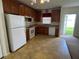 Functional kitchen featuring wood cabinets, white appliances, and a view to the backyard at 2018 Cypress Bay Blvd, Kissimmee, FL 34743