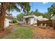 Backyard with privacy fence, featuring mature trees and seating, with shed, ideal for outdoor entertaining and relaxation at 2021 University Dr, Orlando, FL 32804