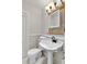 Stylish bathroom featuring a pedestal sink, decorative mirror, and modern lighting at 2021 University Dr, Orlando, FL 32804