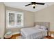 Cozy bedroom with hardwood floors, a ceiling fan, and large windows that provide ample natural light at 2021 University Dr, Orlando, FL 32804