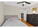 Comfortable bedroom with hardwood floors, a ceiling fan, and a view of an antique dresser and access to the kitchen at 2021 University Dr, Orlando, FL 32804