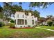 An angle view of a cute home that boasts a stucco exterior, red trim, and green landscaping at 2021 University Dr, Orlando, FL 32804