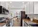 Charming kitchen with granite countertops, white cabinets, stainless steel appliances, and an open view to the living area at 2021 University Dr, Orlando, FL 32804